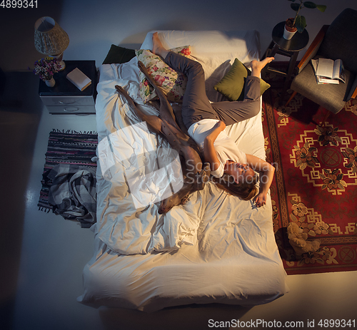 Image of Portrait of a woman, female breeder sleeping in the bed with her dog at home