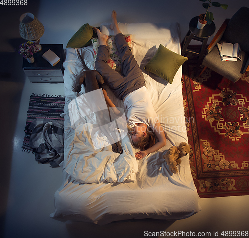 Image of Portrait of a woman, female breeder sleeping in the bed with her dog at home