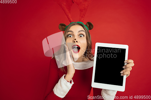 Image of Beautiful woman like Christmas deer isolated on red background. Concept of 2021 New Year\'s, winter mood, holidays.