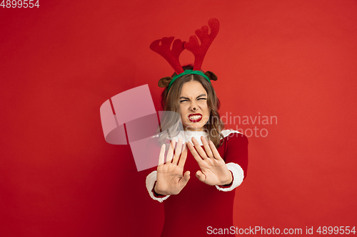 Image of Beautiful woman like Christmas deer isolated on red background. Concept of 2021 New Year\'s, winter mood, holidays.