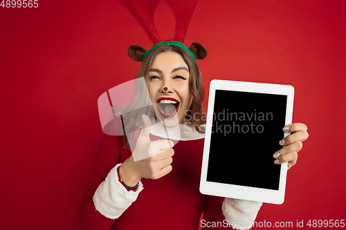 Image of Beautiful woman like Christmas deer isolated on red background. Concept of 2021 New Year\'s, winter mood, holidays.