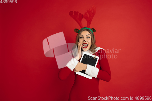 Image of Beautiful woman like Christmas deer isolated on red background. Concept of 2021 New Year\'s, winter mood, holidays.