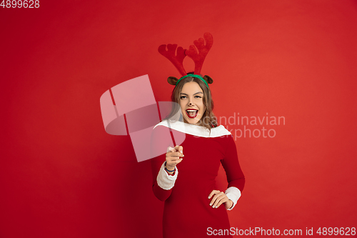 Image of Beautiful woman like Christmas deer isolated on red background. Concept of 2021 New Year\'s, winter mood, holidays.