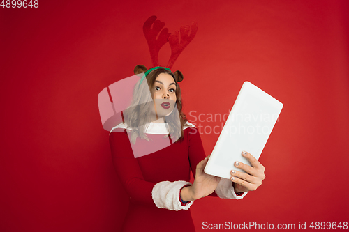 Image of Beautiful woman like Christmas deer isolated on red background. Concept of 2021 New Year\'s, winter mood, holidays.