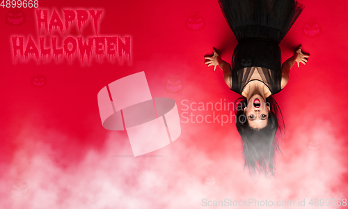 Image of Young woman a witch on scary background