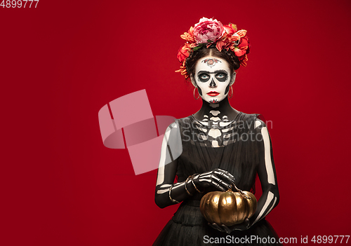 Image of Young girl in the image of Santa Muerte, Saint death or Sugar skull with bright make-up. Portrait isolated on studio background.