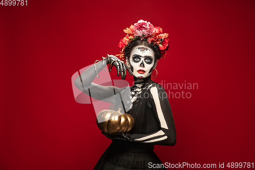 Image of Young girl in the image of Santa Muerte, Saint death or Sugar skull with bright make-up. Portrait isolated on studio background.