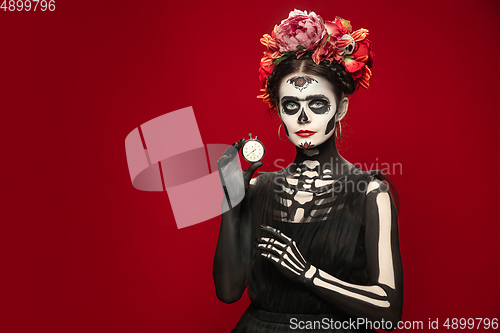 Image of Young girl in the image of Santa Muerte, Saint death or Sugar skull with bright make-up. Portrait isolated on studio background.