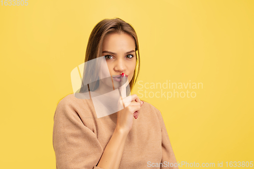 Image of Portrait of young caucasian woman with bright emotions isolated on yellow studio background