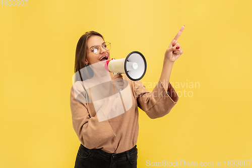 Image of Portrait of young caucasian woman with bright emotions isolated on yellow studio background