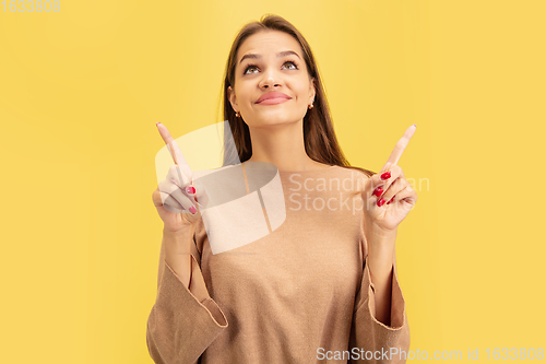 Image of Portrait of young caucasian woman with bright emotions isolated on yellow studio background