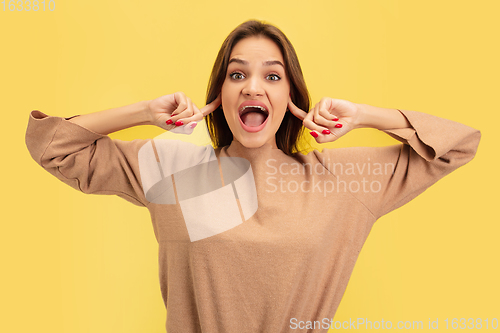 Image of Portrait of young caucasian woman with bright emotions isolated on yellow studio background