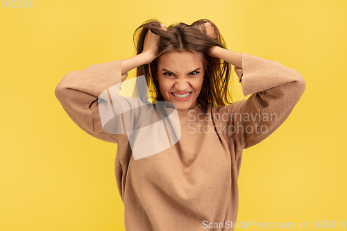 Image of Portrait of young caucasian woman with bright emotions isolated on yellow studio background