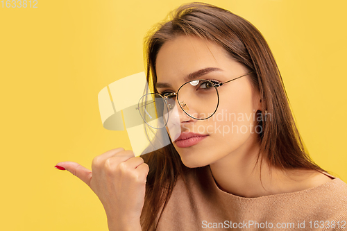 Image of Portrait of young caucasian woman with bright emotions isolated on yellow studio background