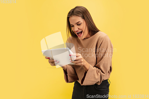Image of Portrait of young caucasian woman with bright emotions isolated on yellow studio background