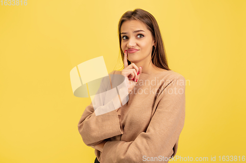 Image of Portrait of young caucasian woman with bright emotions isolated on yellow studio background