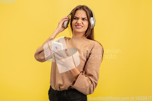 Image of Portrait of young caucasian woman with bright emotions isolated on yellow studio background