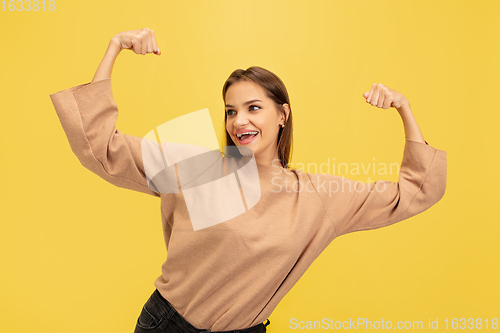 Image of Portrait of young caucasian woman with bright emotions isolated on yellow studio background