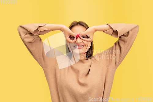 Image of Portrait of young caucasian woman with bright emotions isolated on yellow studio background