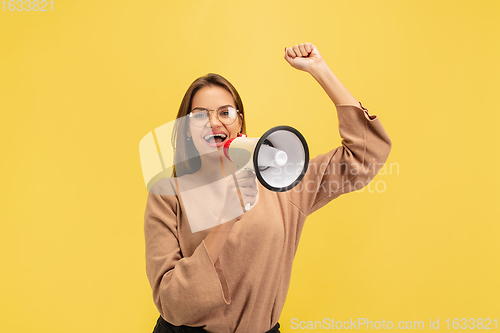 Image of Portrait of young caucasian woman with bright emotions isolated on yellow studio background