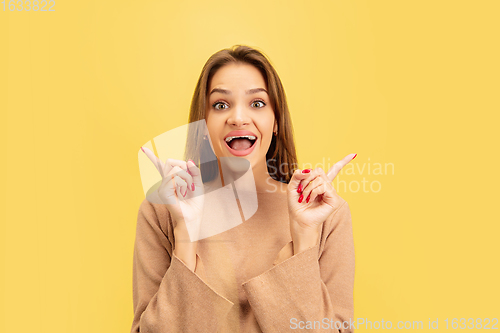 Image of Portrait of young caucasian woman with bright emotions isolated on yellow studio background