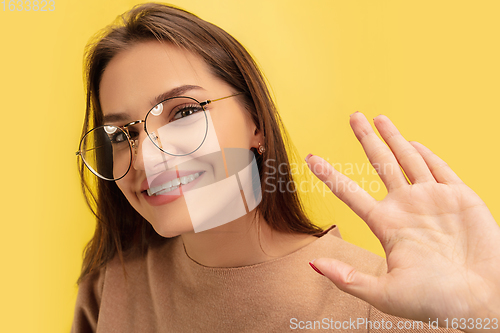 Image of Portrait of young caucasian woman with bright emotions isolated on yellow studio background