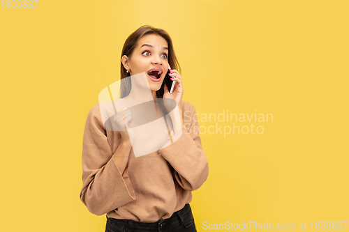 Image of Portrait of young caucasian woman with bright emotions isolated on yellow studio background