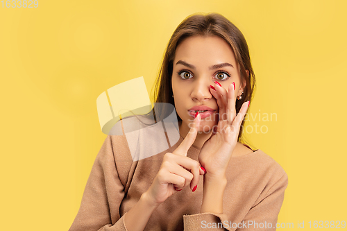 Image of Portrait of young caucasian woman with bright emotions isolated on yellow studio background