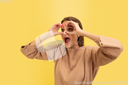 Image of Portrait of young caucasian woman with bright emotions isolated on yellow studio background