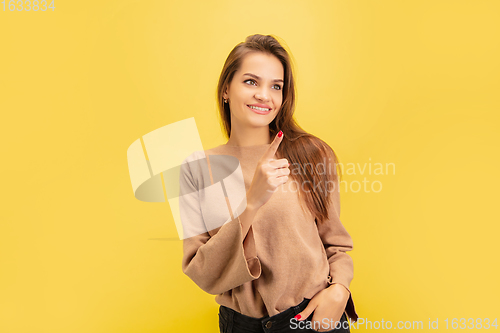 Image of Portrait of young caucasian woman with bright emotions isolated on yellow studio background