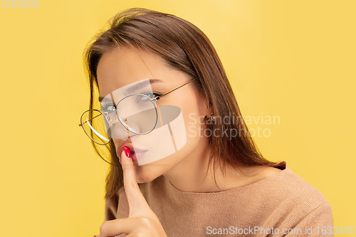 Image of Portrait of young caucasian woman with bright emotions isolated on yellow studio background