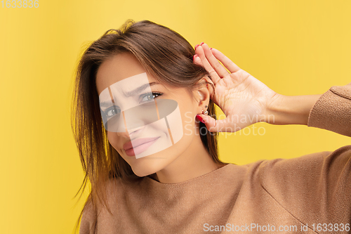 Image of Portrait of young caucasian woman with bright emotions isolated on yellow studio background