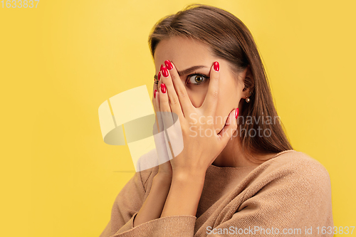 Image of Portrait of young caucasian woman with bright emotions isolated on yellow studio background