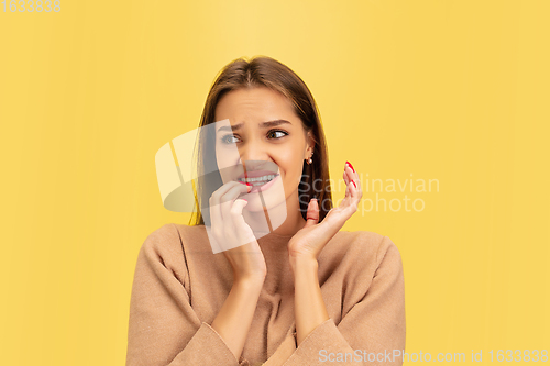 Image of Portrait of young caucasian woman with bright emotions isolated on yellow studio background