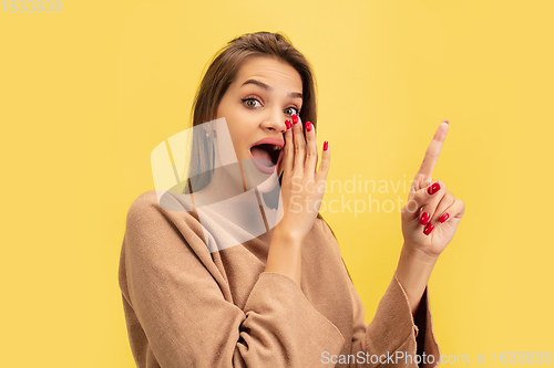 Image of Portrait of young caucasian woman with bright emotions isolated on yellow studio background