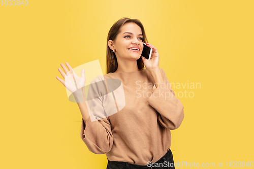 Image of Portrait of young caucasian woman with bright emotions isolated on yellow studio background