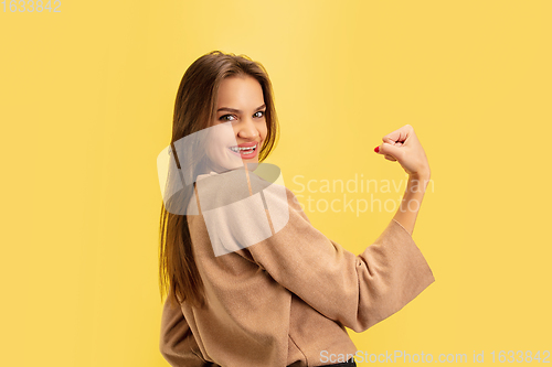 Image of Portrait of young caucasian woman with bright emotions isolated on yellow studio background