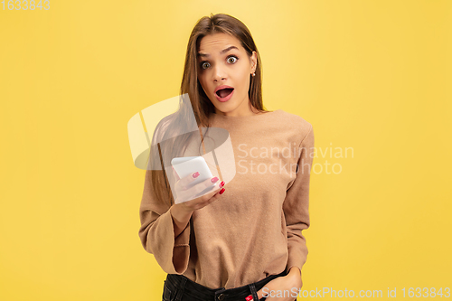 Image of Portrait of young caucasian woman with bright emotions isolated on yellow studio background