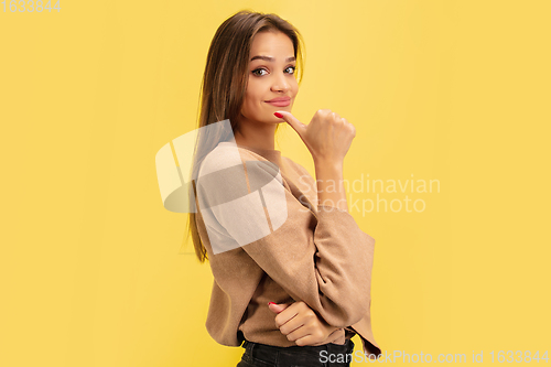 Image of Portrait of young caucasian woman with bright emotions isolated on yellow studio background