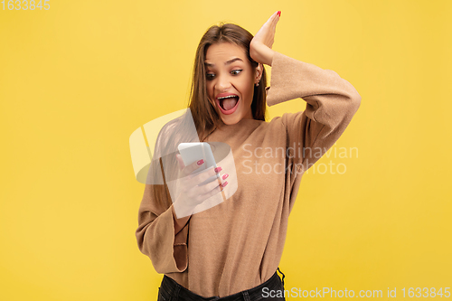 Image of Portrait of young caucasian woman with bright emotions isolated on yellow studio background