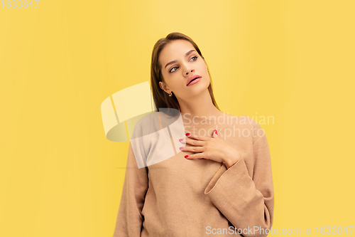 Image of Portrait of young caucasian woman with bright emotions isolated on yellow studio background