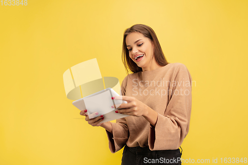 Image of Portrait of young caucasian woman with bright emotions isolated on yellow studio background