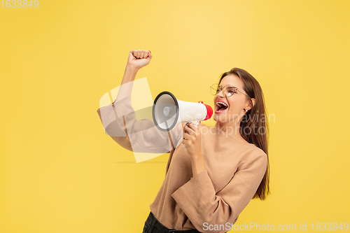 Image of Portrait of young caucasian woman with bright emotions isolated on yellow studio background