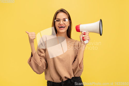 Image of Portrait of young caucasian woman with bright emotions isolated on yellow studio background