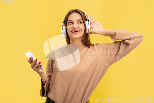 Image of Portrait of young caucasian woman with bright emotions isolated on yellow studio background