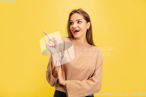 Image of Portrait of young caucasian woman with bright emotions isolated on yellow studio background