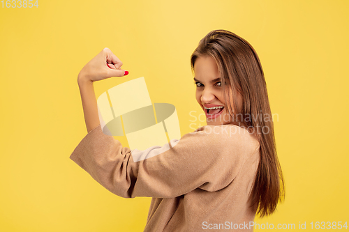 Image of Portrait of young caucasian woman with bright emotions isolated on yellow studio background