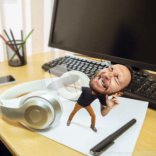 Image of Tired man, office worker holding his huge tired head, funny