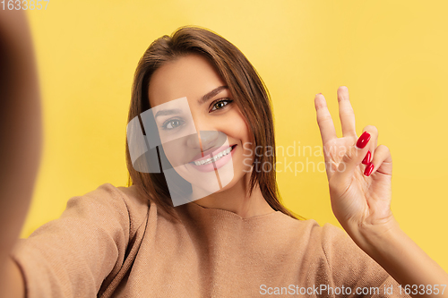 Image of Portrait of young caucasian woman with bright emotions isolated on yellow studio background