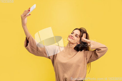 Image of Portrait of young caucasian woman with bright emotions isolated on yellow studio background